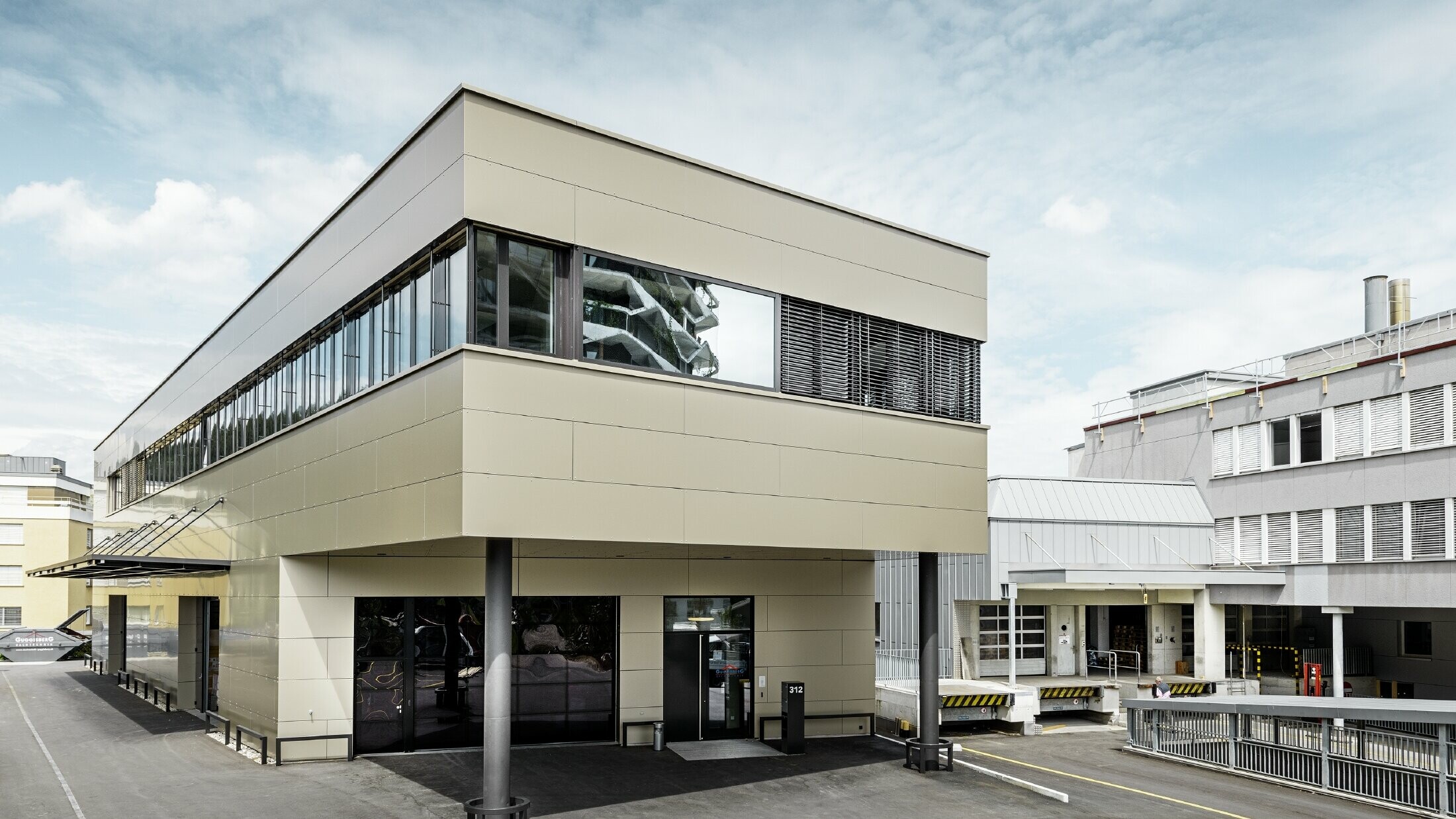 Moderne tilbygning med værksted og kontor fra Guggisbau Dachtechnik med PREFA aluminiumskompositplade i bronze