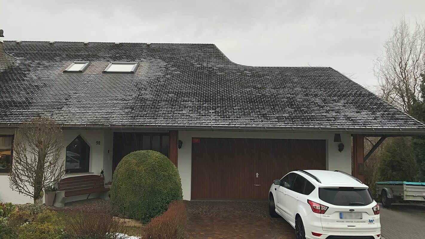 Einfamilienhaus mit Garage vor der Dachsanierung mit der PREFA Dachplatte R.16 in Braun