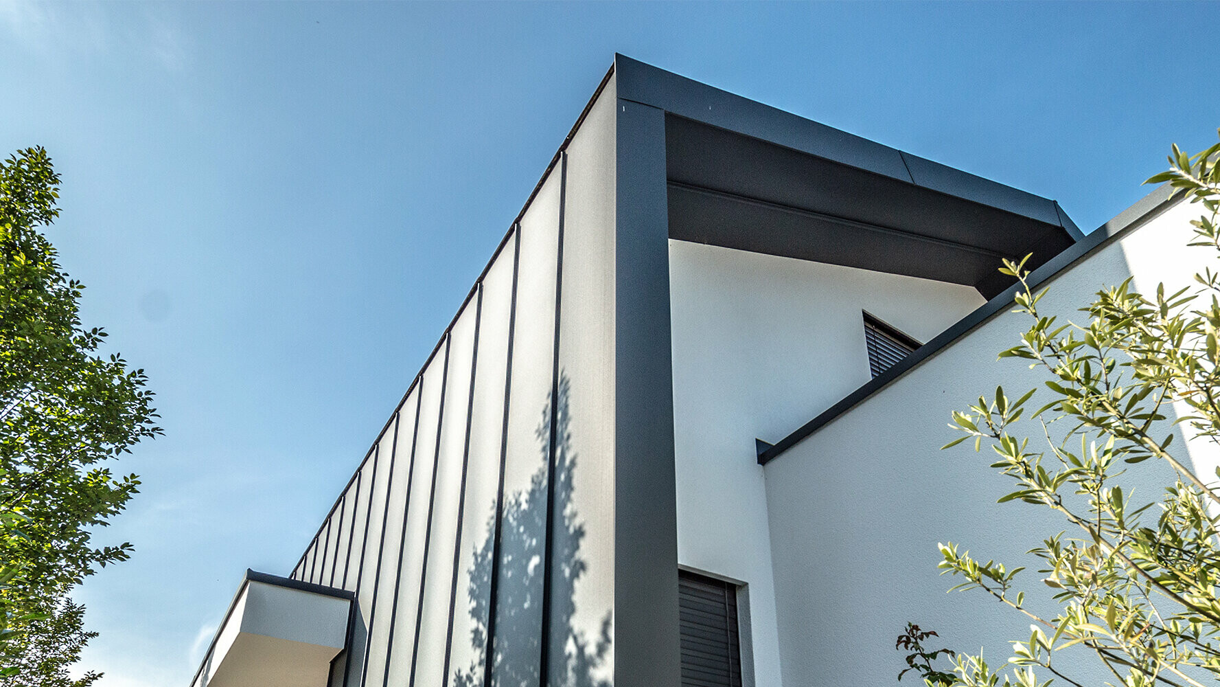 Moderne parcelhus med kreativt facadedesign: PREFA Sidings i en blanding af sølv og mat antracit.