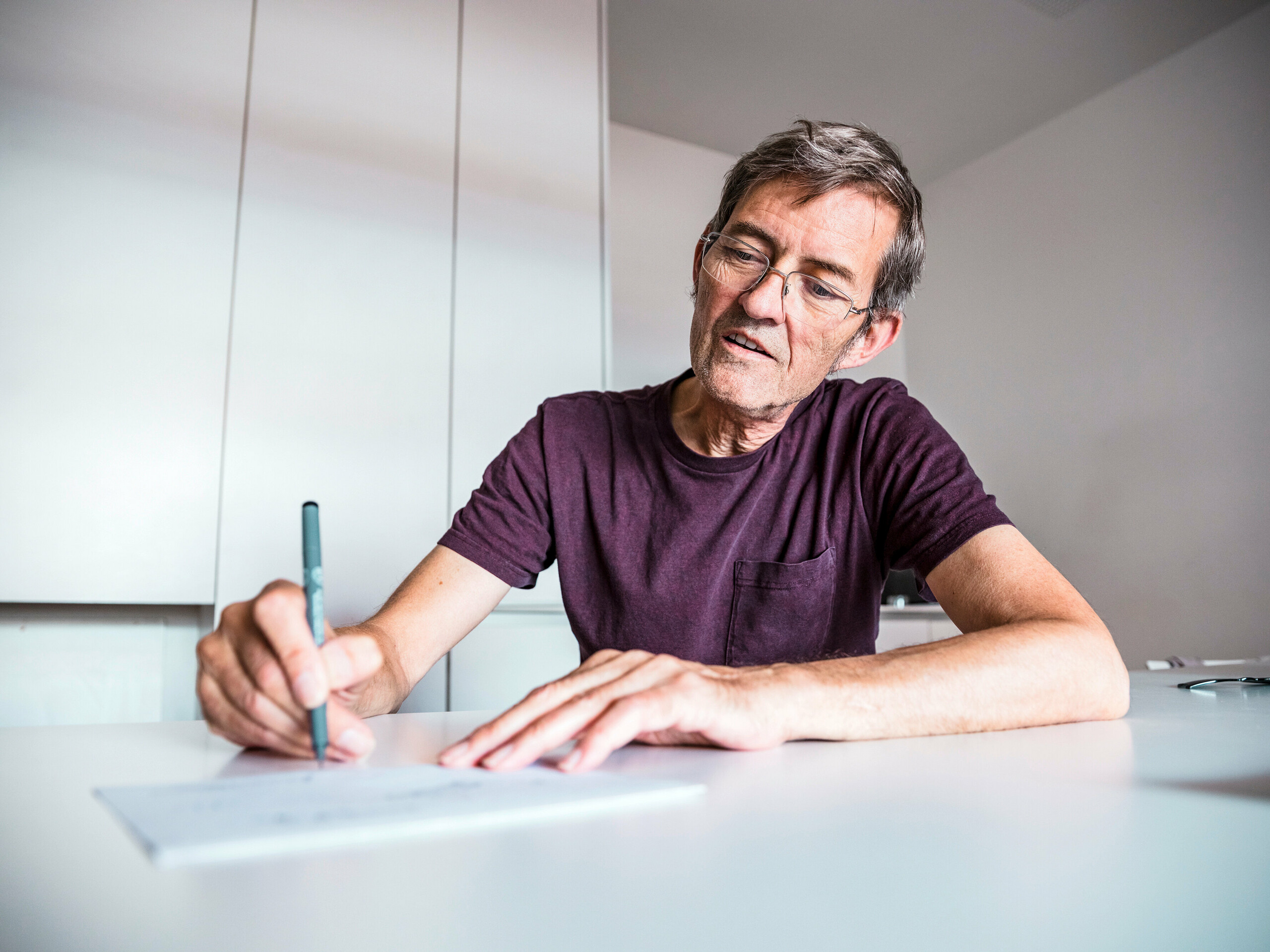 Foto des Architekten Domenique Cornaert, während er an einer Zeichnung arbeitet.