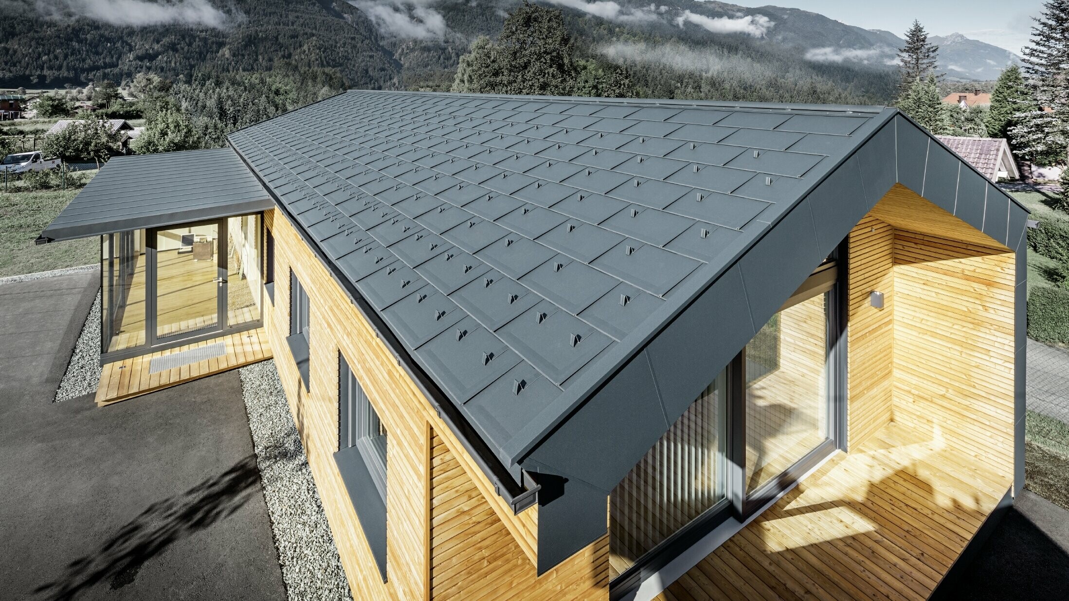 Ny kontorbygning fra Holzbau Faltheiner med lærketræfacade, store vinduesflader og et PREFA-tag i antracit.