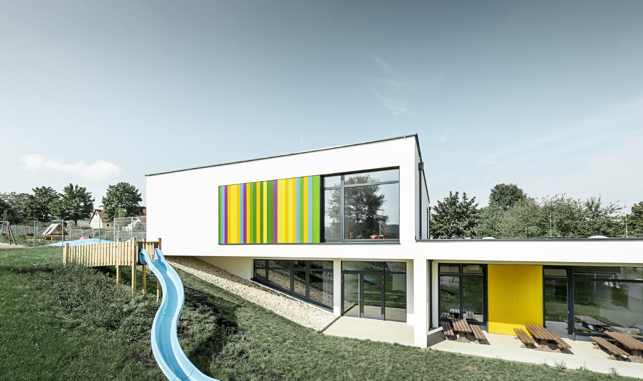 Børnehaven i Hargelsberg set fra bagsiden med farverig, PREFAs takkede profil i farverne gul, grøn, lilla og blå