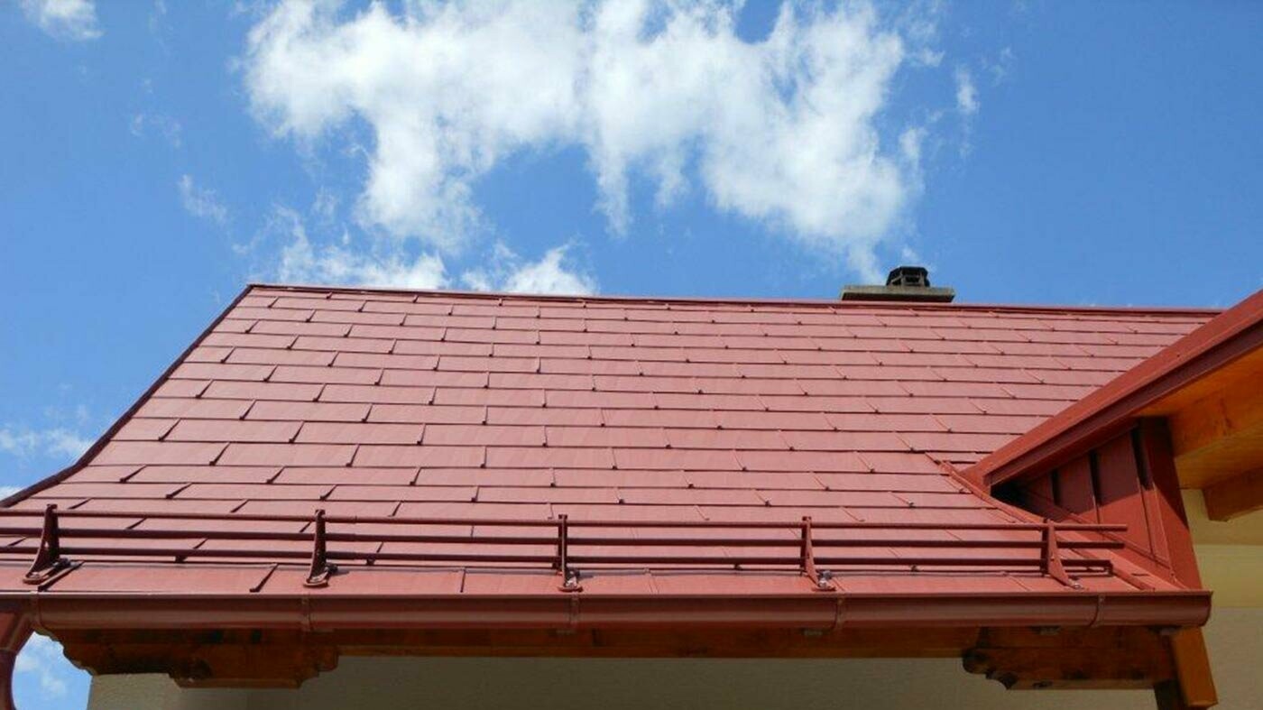 Detaljeret overblik over taget med PREFA tagpanel FX.12 i oxidrød med snestopper.