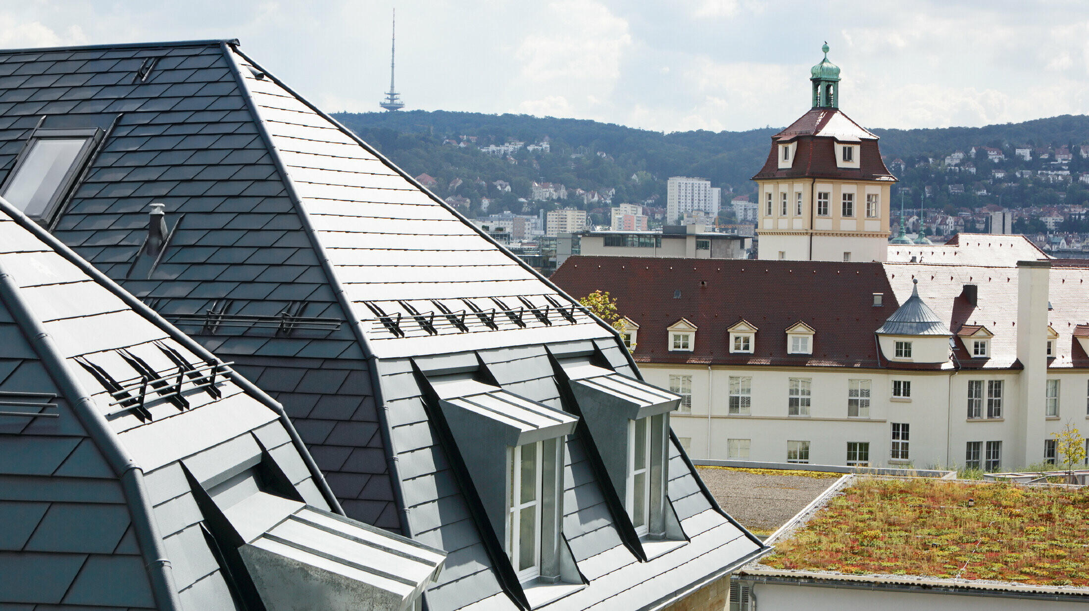 Gammelt byhus i Stuttgart med skråt tag og mange kvistvinduer, beklædt med PREFA-tagspån i aluminium i P.10 antracit