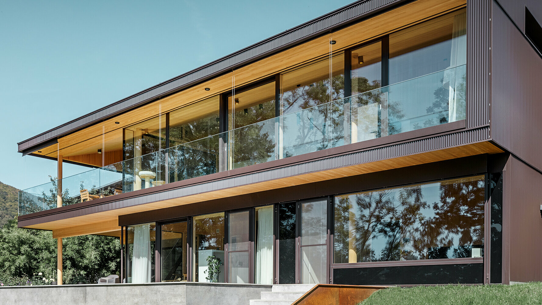 Nyt enfamilieshus med store glasflader og facade af brunt aluminium