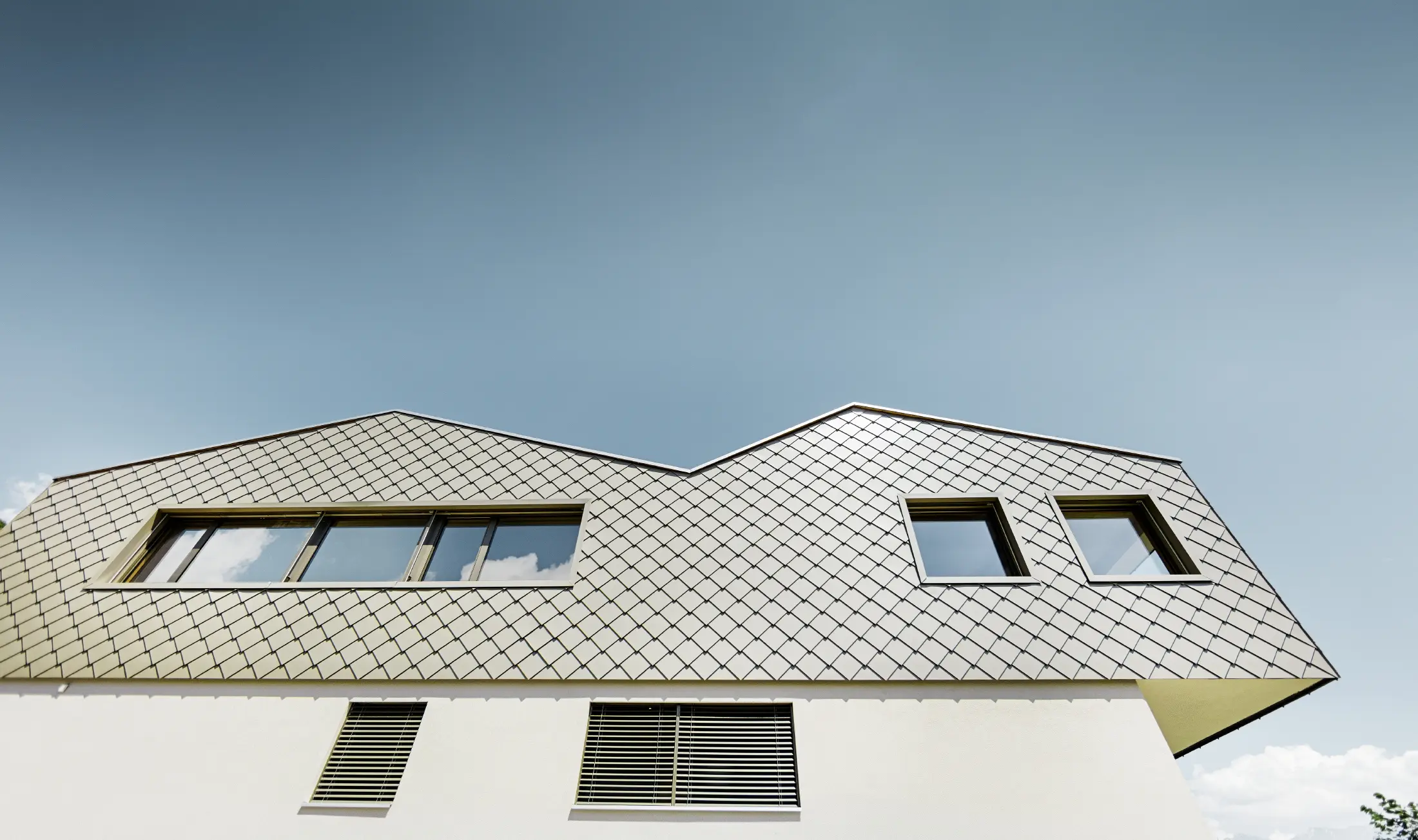 Moderne enfamilieshus midt i vinbjergene i Rhône-dalen med 4 forskellige tagflader og åbent galleri med en rombefacade i bronze