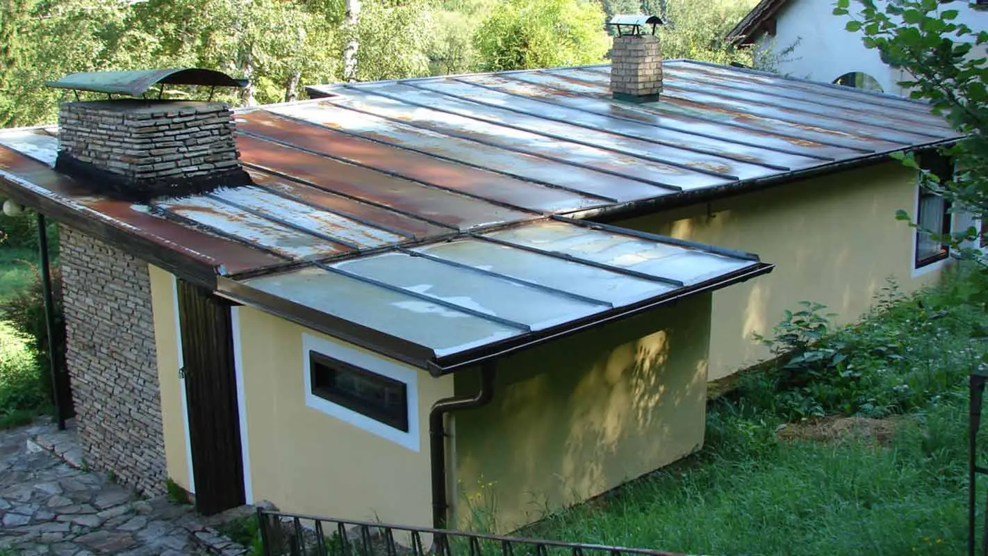 Rustfrit tag på anneks før renovering med prefalz fra PREFA