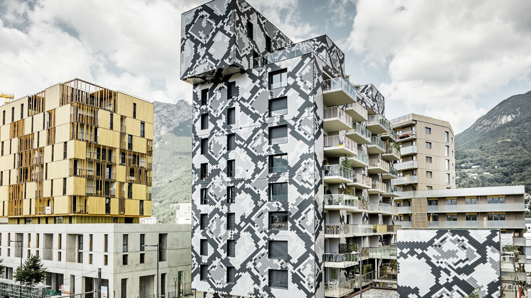 Imponerende facadedesign på beboelsesejendommen "le Python" med slangemønsteret. Facaden er udført med PREFA vægromber i farverne antracit, lysegrå, naturblank og sølvmetallic.