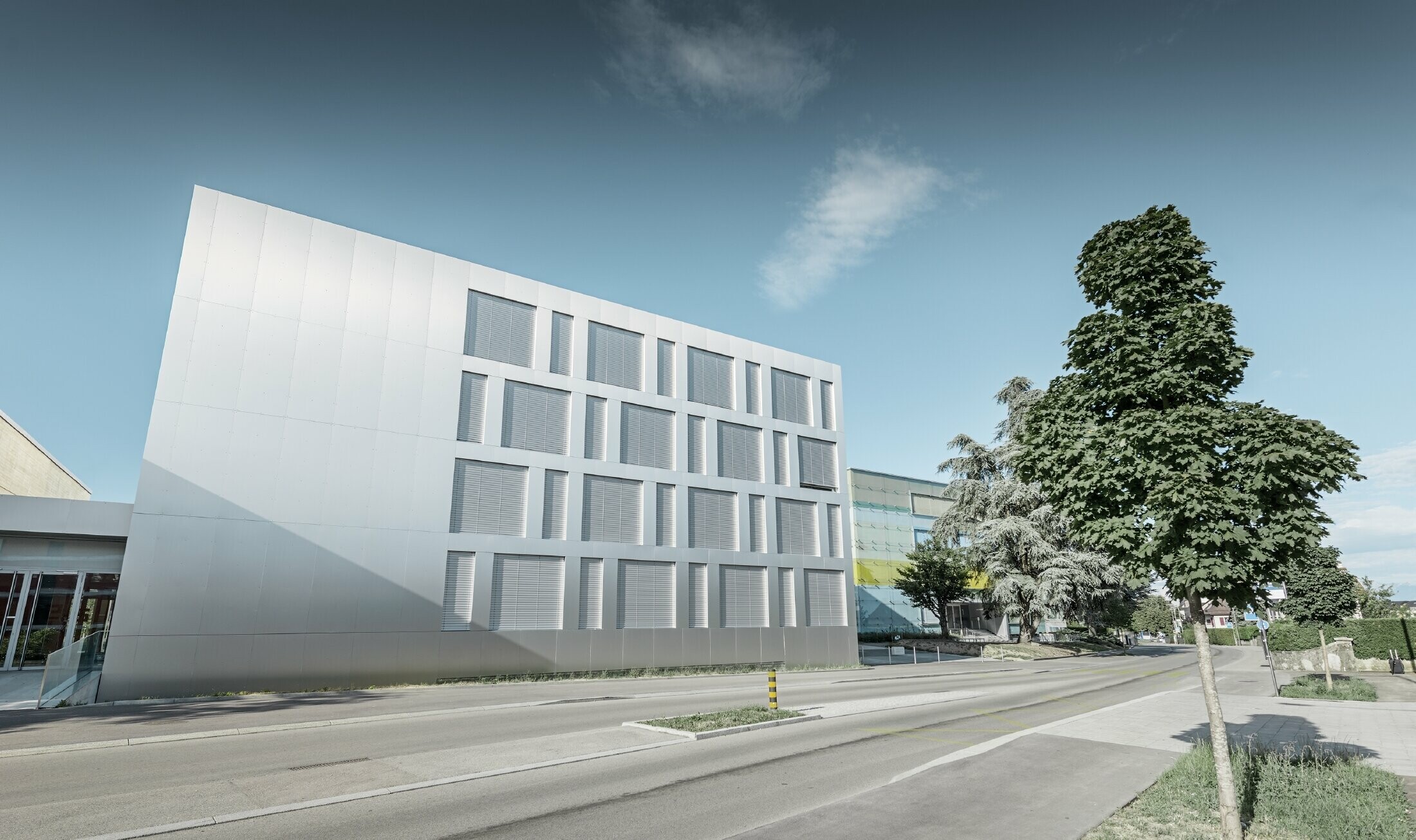 Moderne skolebygning med fladt tag og en facade med PREFA kompositplader i børstet aluminium