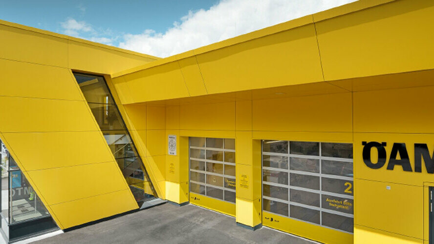 ÖAMTC filial med PREFA kompositplader i rapsgul, der er monteret som gardinventileret facade.