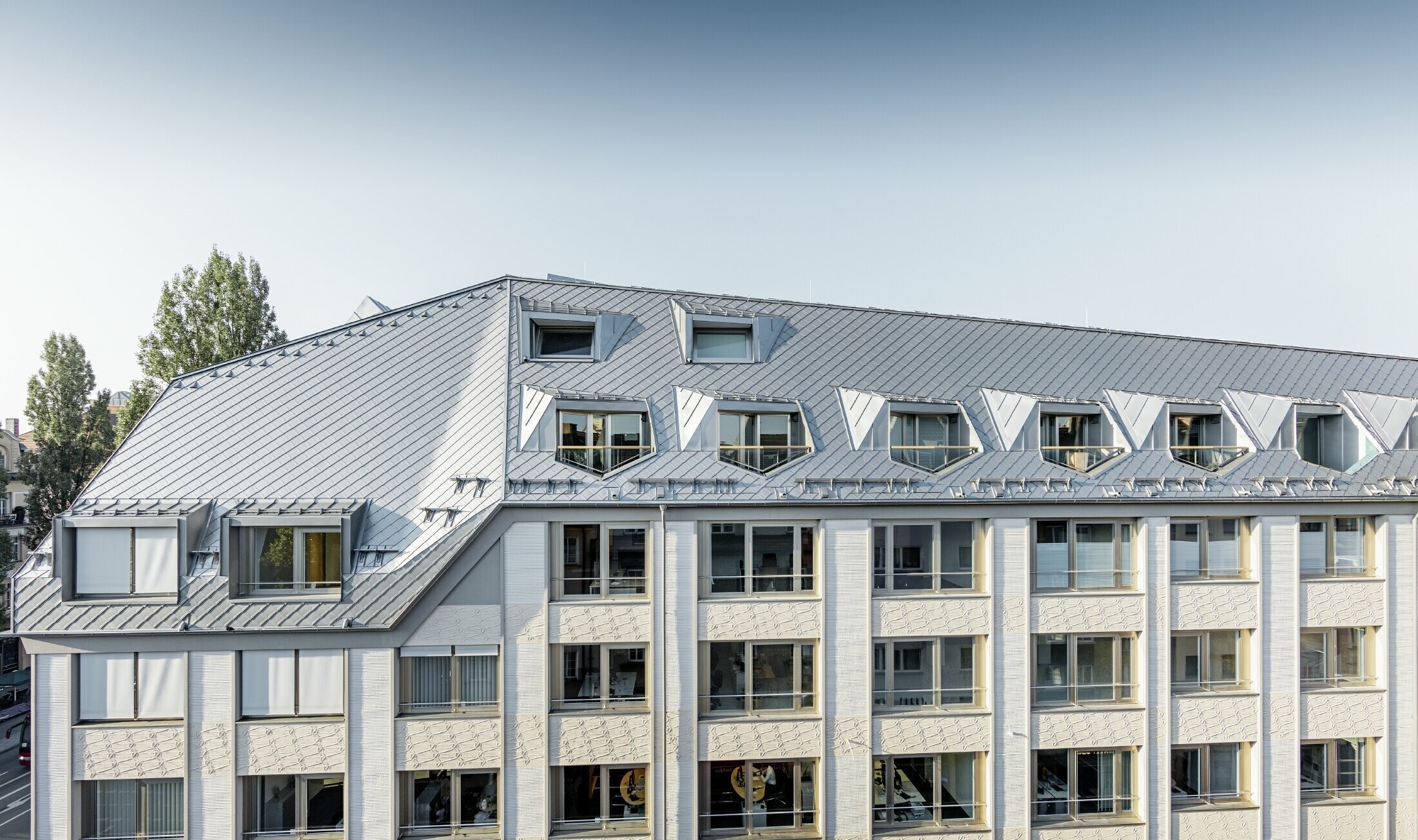 Saneret kvistlejlighed med storstilet åbent galleriniveau i en bolig- og forretningsejendom i Leopoldstraße/Ecke Hohenzollernstraße i München med en tagdækning fra PREFA - tagrombe