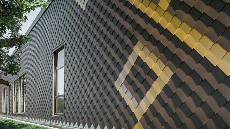 Facade med brune PREFA vægromber i 20 × 20. Kulørte romber i guld danner et mønster på facaden.