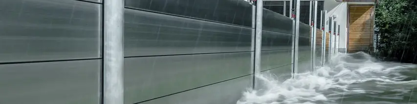 Nærbillede af PREFA-højvandsbeskyttelsen af aluminium, som altid modstår oversvømmelseskatastrofer og beskytter parcelhuset i baggrunden.