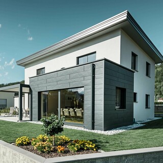 Parcelhus med tilbygning, tilbygningen er beklædt med PREFA-aluminiumsfacade, det flade tag afvandes ved hjælp af et PREFA-udløb og PREFA-afløbsrør i P.10 antracit,