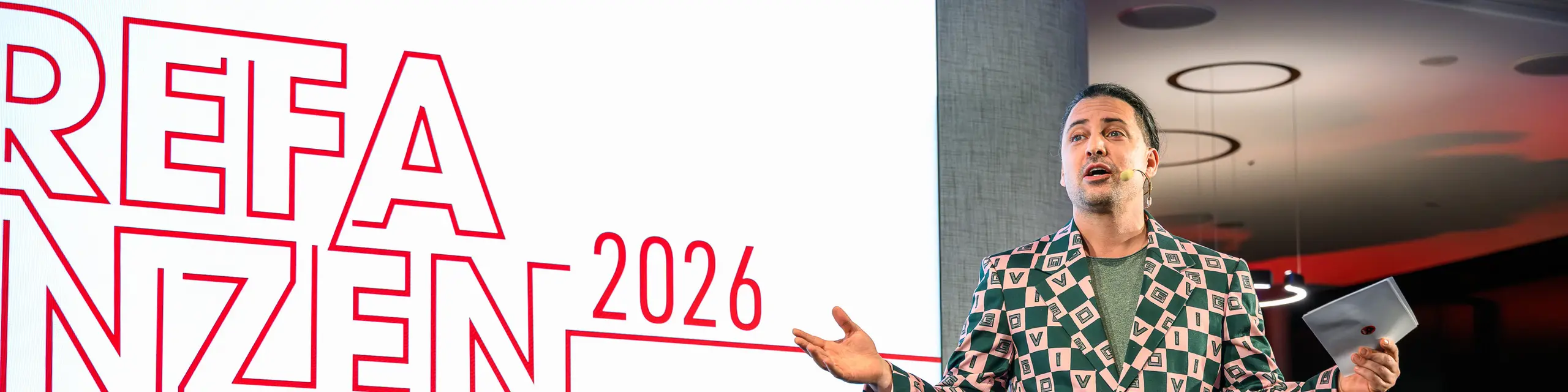 Bühnenmoment mit Wow-Effekt bei der PREFARENZEN Präsentation 2026: Moderator Serkan Temel begeistert das Publikum mit Charme, Humor und auffälligem Outfit. Seine Präsenz unterstreicht den kreativen Geist der Veranstaltung, die Innovation, Design und Gemeinschaft vereint. Ein Highlight-Abend im k47.wien, der zeigt, wie modern und vielseitig Aluminiumarchitektur mit PREFA heute gedacht und gelebt wird.