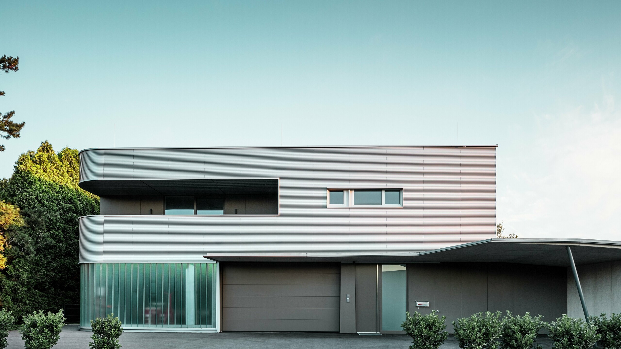 Moderne bolighus med naturblank facade af PREFA-profilbølge med garage