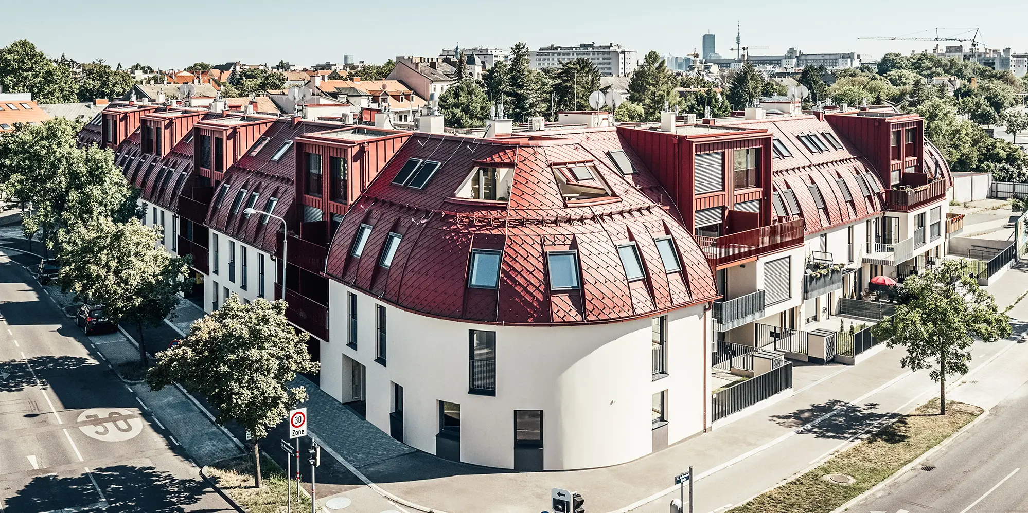 Gadeudsigt over boligkomplekset Schöneck 13 og det afrundede taglandskab, designet af arkitektfirmaet schneider+schumacher.