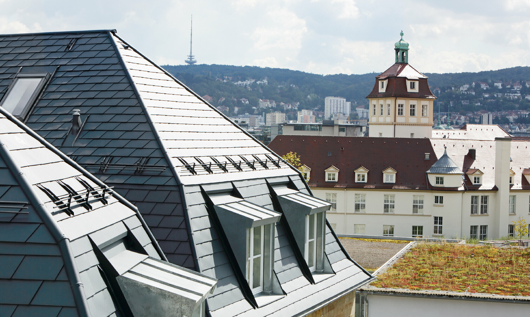 Gammelt byhus i Stuttgart med skråt tag og mange kvistvinduer, beklædt med PREFA-tagspån i aluminium i P.10 antracit