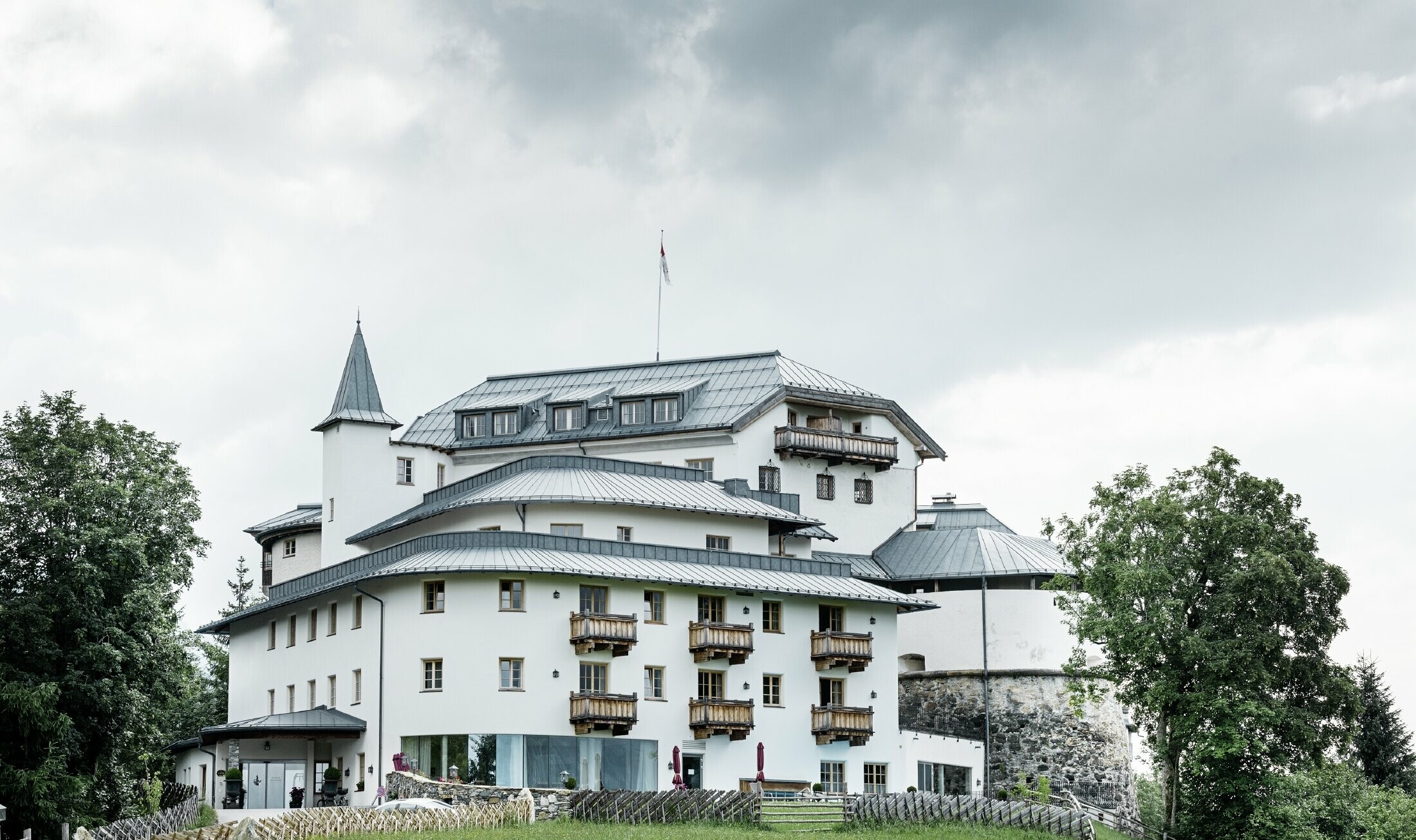 Schloss Mittersill omgivet af træer og bjerge med et nyt saneret Prefalz tag i stengrå