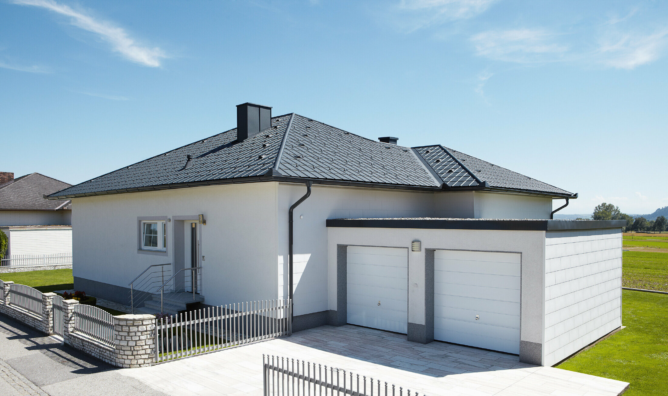 Den nybyggede bungalow med telttag blev dækket med PREFA tagplader i P.10 antracit. Der blev tilføjet en dobbeltgarage til højre, fotograferet fra gaden.