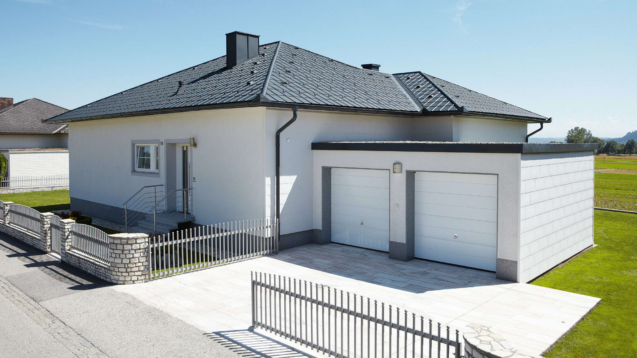 Den nybyggede bungalow med telttag blev dækket med PREFA tagplader i P.10 antracit. Der blev tilføjet en dobbeltgarage til højre, fotograferet fra gaden.