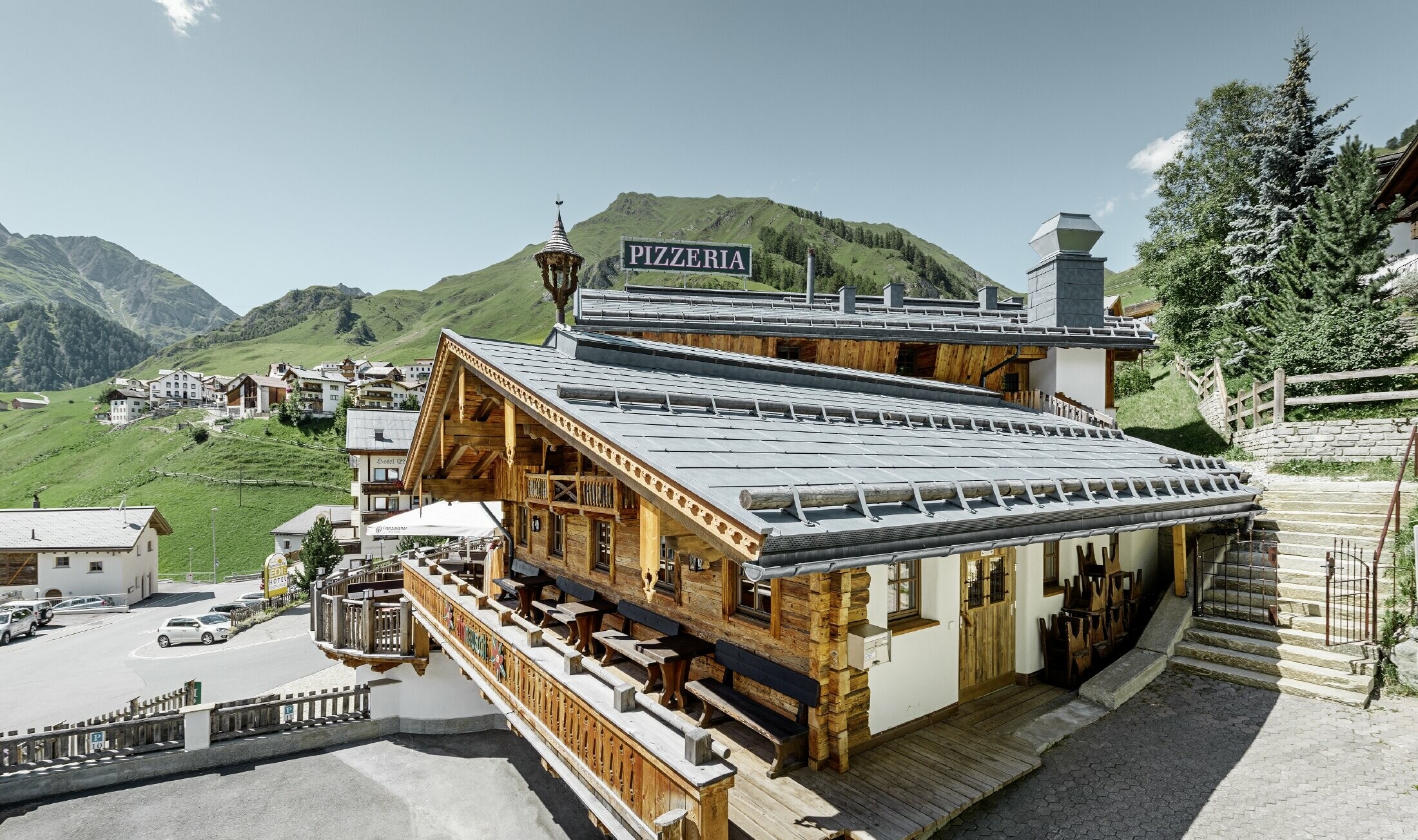 Restaurant Almrausch med bjerge i baggrunden og et PREFA tag med tagpanel FX.12 in stengrå og bjergsnestøtter