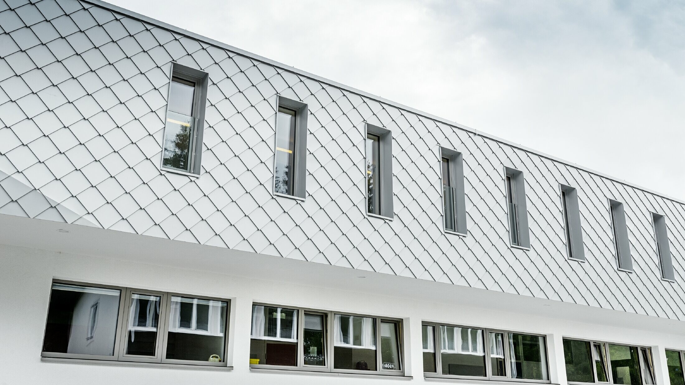 Nybygget børnehave i Kaprunn med en moderne aluminiumsfacade med PREFA-vægrombe i Prefa-hvid
