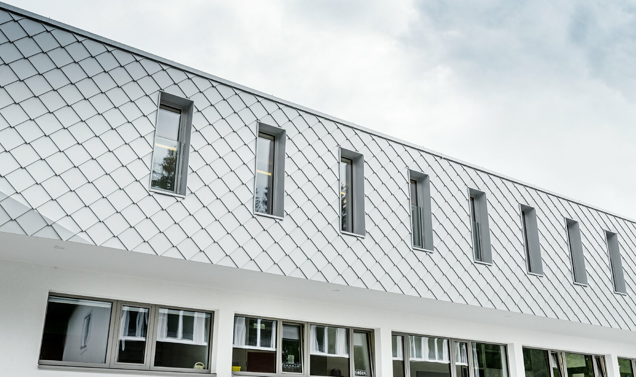 Nybygget børnehave i Kaprunn med en moderne aluminiumsfacade med PREFA-vægrombe i Prefa-hvid
