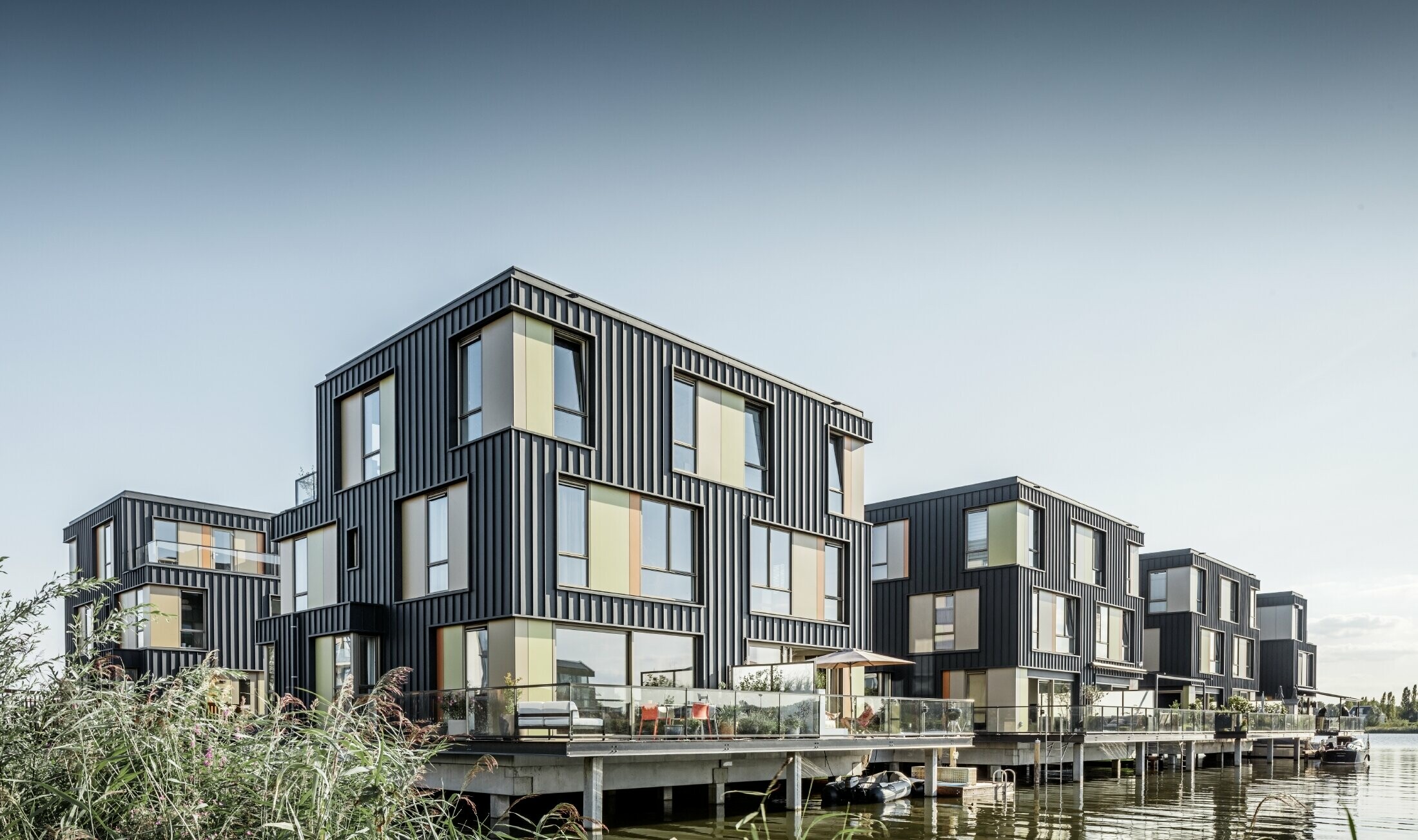 Nyt boligområde med tofamilieshuse ved en sø i Amsterdam. Husene er beklædt med Prefalz fra PREFA i P.10 antracit.