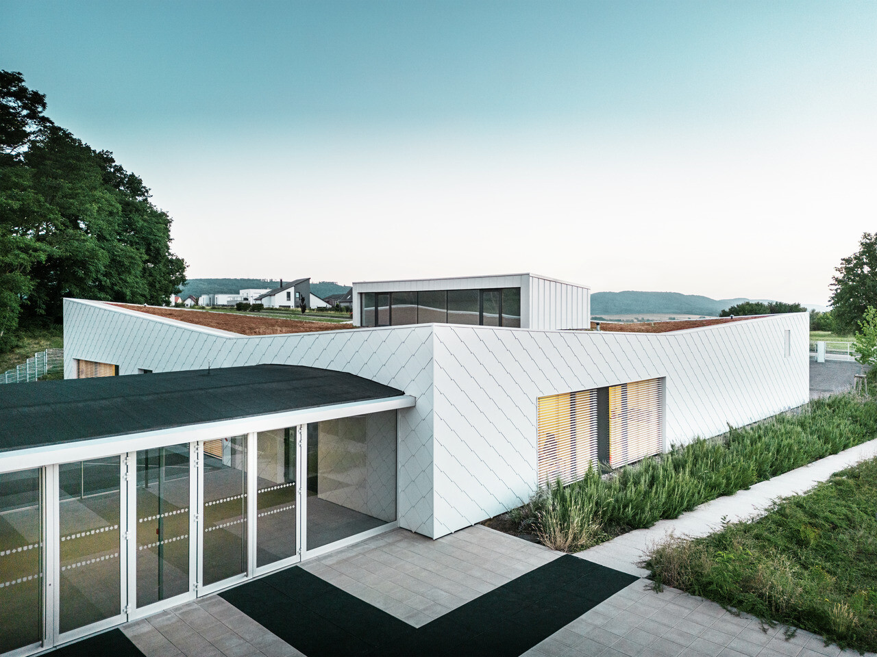 Das neu errichtete Kindergarten- und Schulgebäude in Otterswiller mit der PREFA Wandraute 44 × 44 in P.10 Prefaweiss.