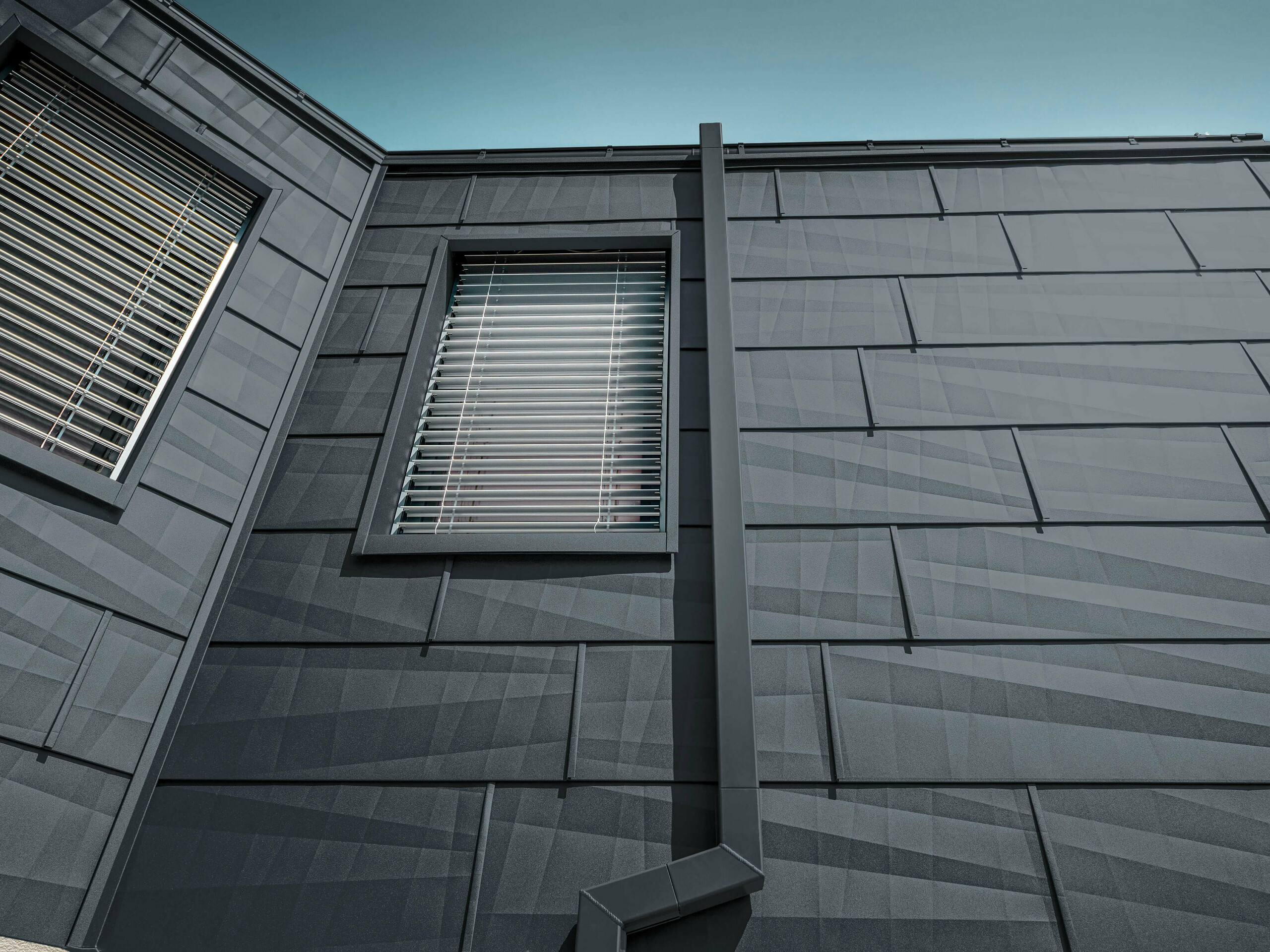 Facade beklædt med PREFA-facadepanel FX.12 i antracit, alupaneler på facaden med kantet nedløbsrør, kvadratrør, i antracit fra PREFA.
