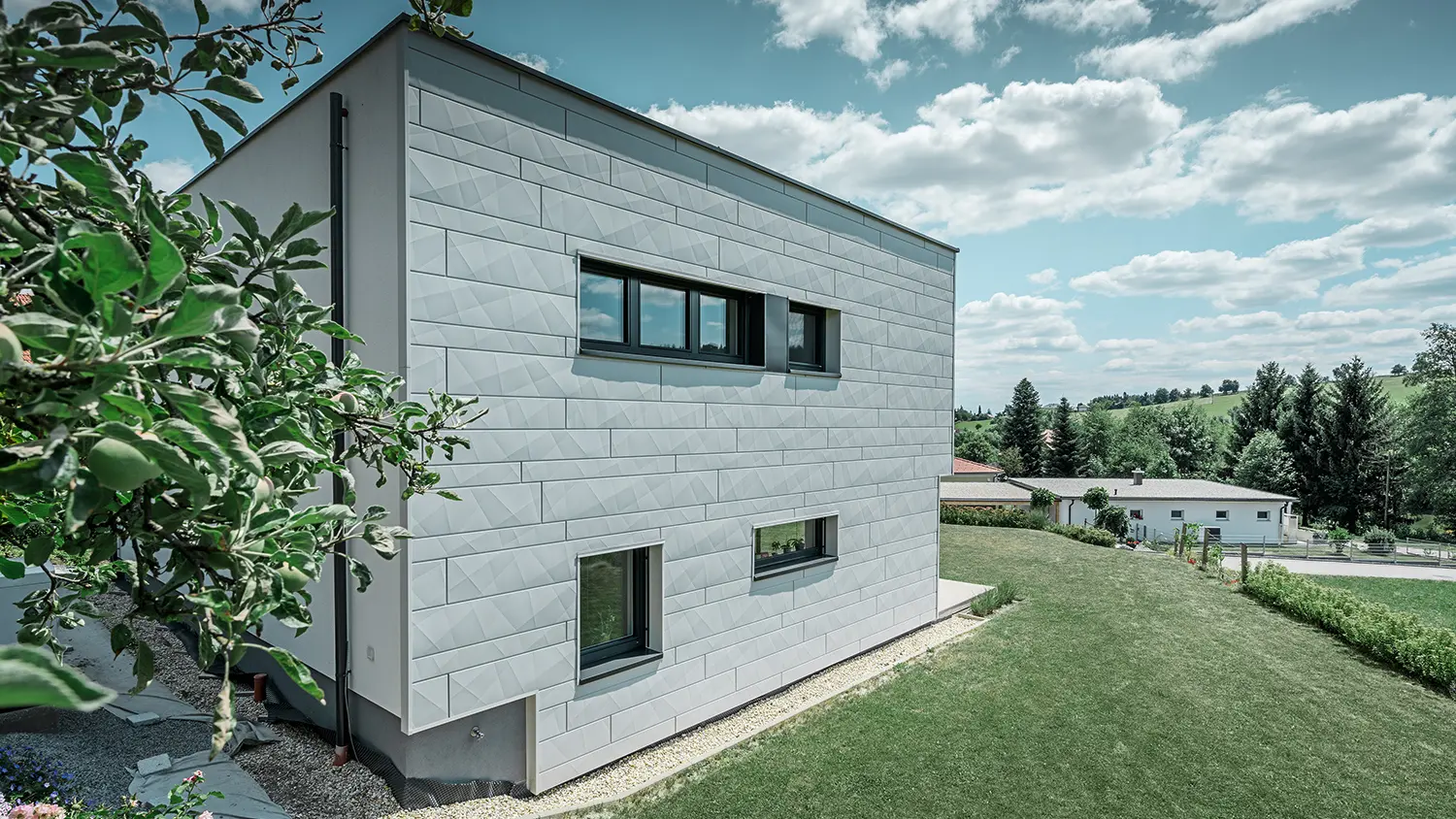 Set fra siden af et moderne enfamiliehus med udsigt til Siding.X-facaden.