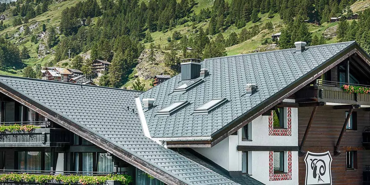 Hotelalpenhof i Zermatt med Matterhorn i baggrunden, balkoner, mørk træfacade og et PREFA aluminiumtag i antracit
