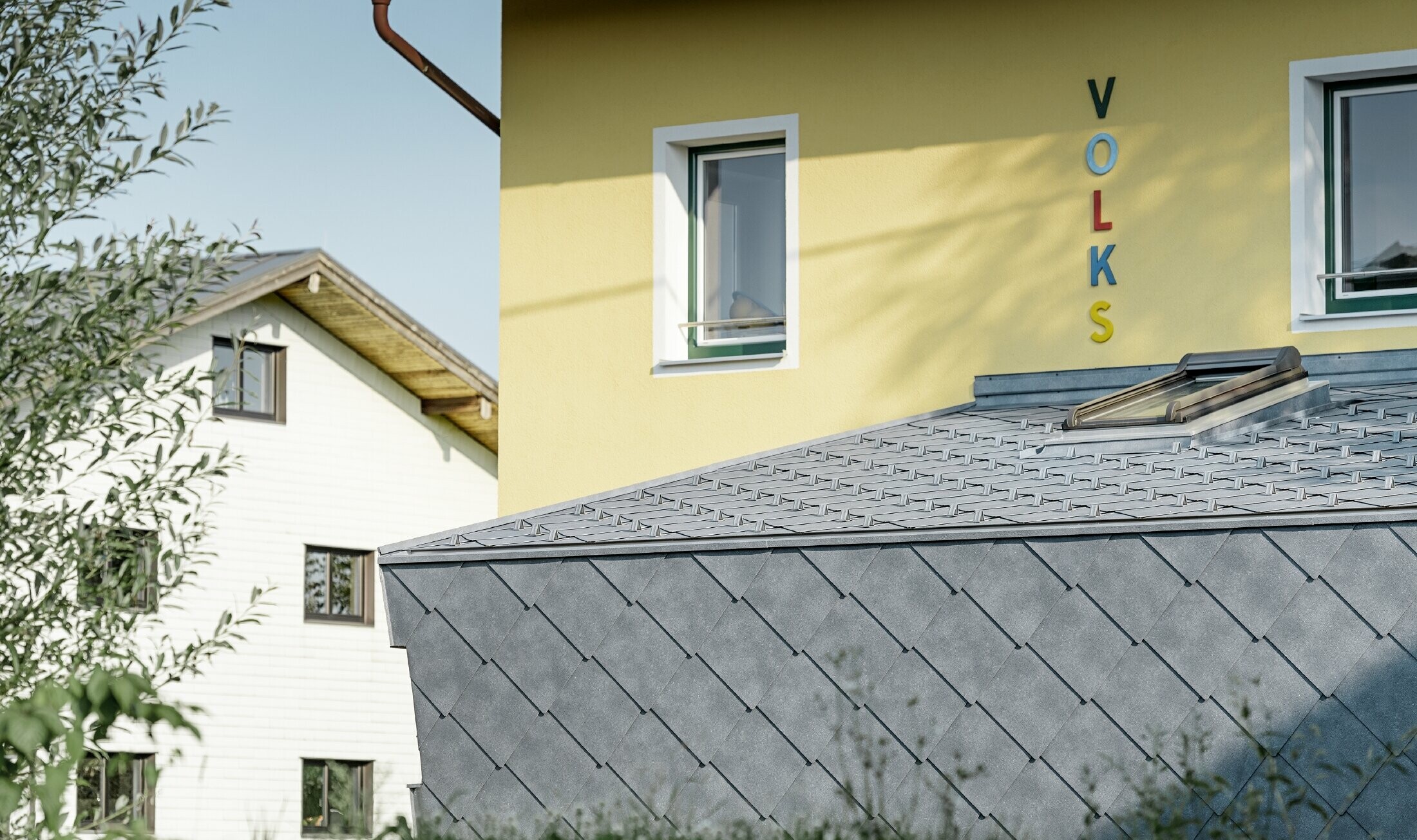 Tilbygning til en folkeskole dækket med tag- og vægrombe af aluminium fra PREFA i stengrå
