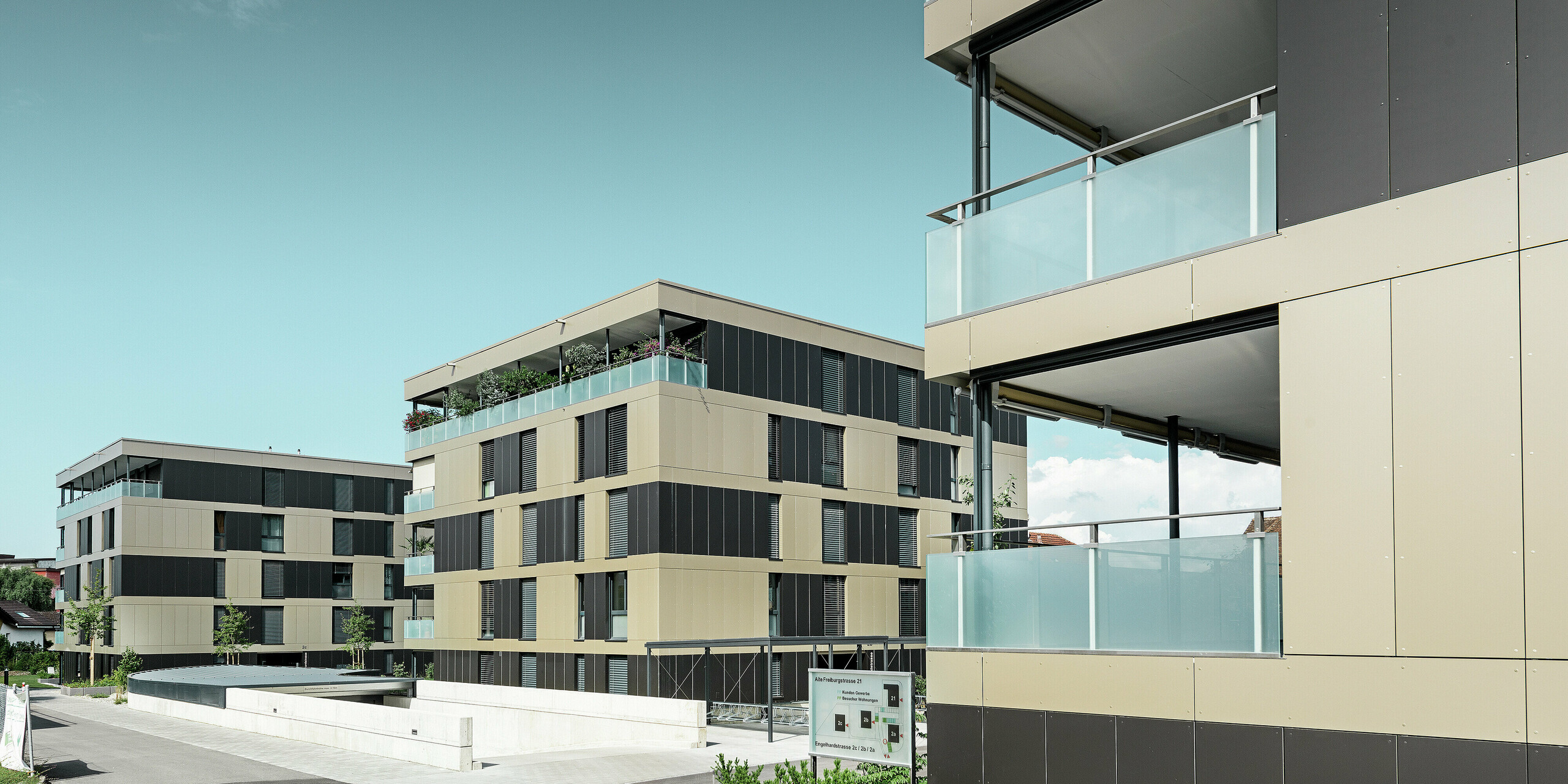 Die moderne Wohnanlage in Murten (CH) beeindruckt mit einer PREFA Fassade, die mit Aluminium Verbundplatten in den Farben Bronze und Schwarzgrau ausgestattet wurde. Diese Kombination sorgt für ein zeitloses und elegantes Erscheinungsbild. Die langlebigen Platten bieten nicht nur ästhetische Vorteile, sondern auch einen hervorragenden Witterungsschutz, der die Fassade funktionell und attraktiv macht.