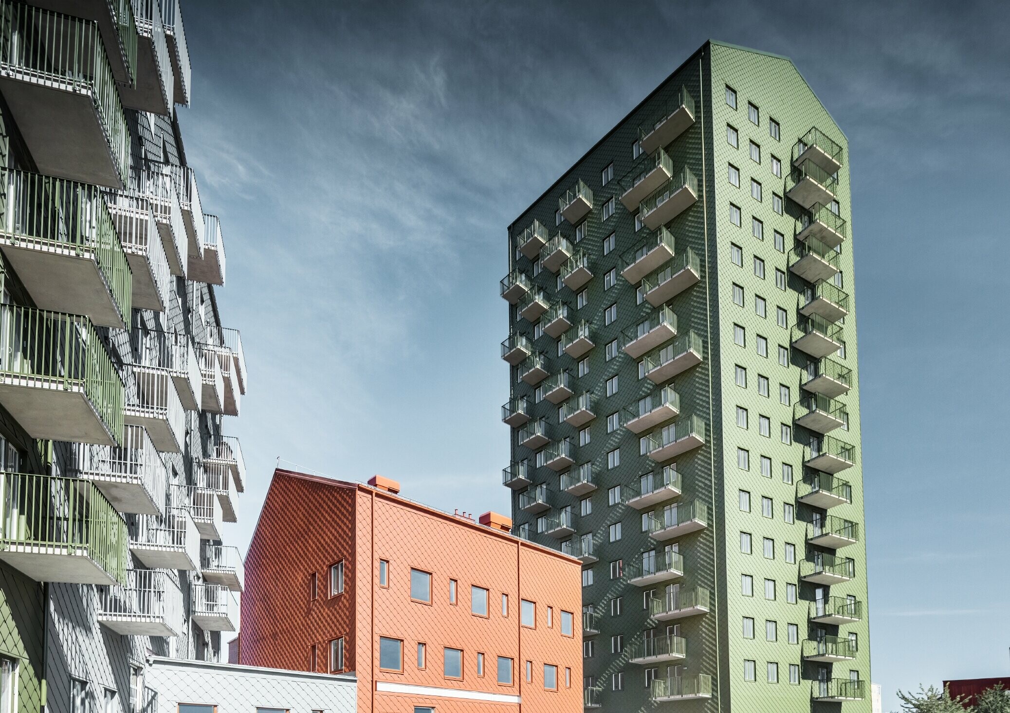 Flere boligblokke beklædt med PREFA-vægrombe 29 × 29 i farverne olivengrøn, murstensrød og lysegrå i Göteborg, Sverige.