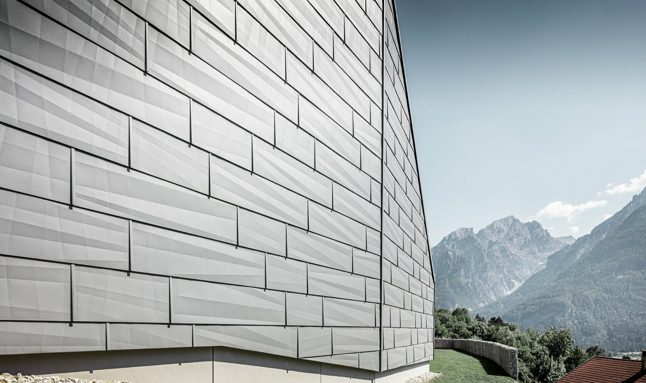 Den vejrudsatte side af et enfamilieshus i Lienz, Østrig, er beklædt med PREFA-facadepanel FX.12 i P.10 lysegrå.