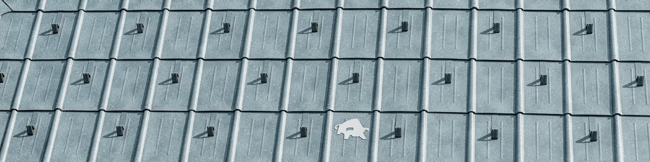 PREFA-tagplade opsat med PREFA’s logo med tyr i P.10 stengrå; tagflade med PREFA-pladetag;