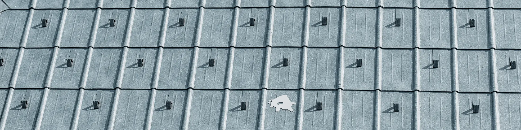 PREFA-tagplade opsat med PREFA’s logo med tyr i P.10 stengrå; tagflade med PREFA-pladetag;