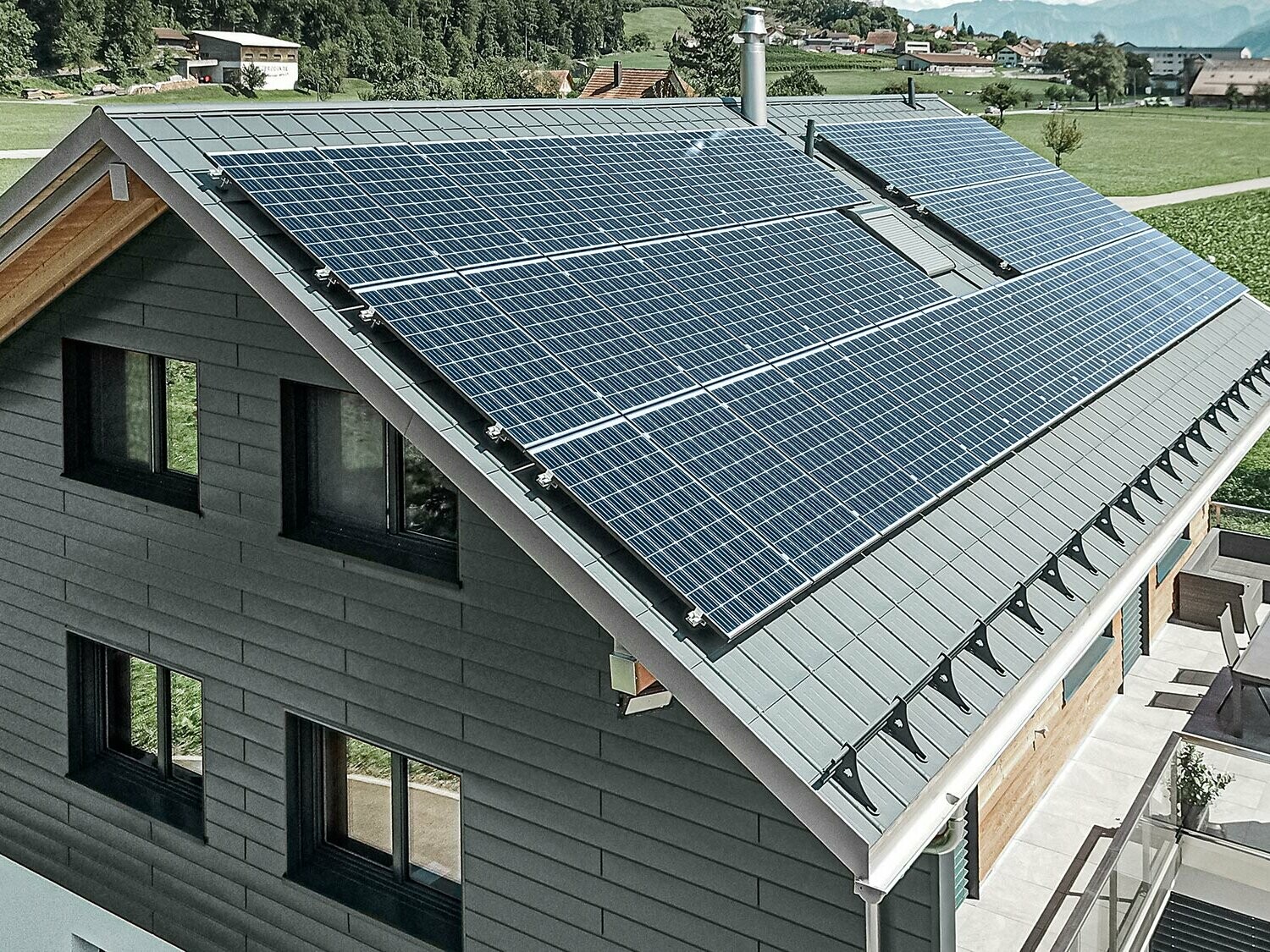 Solcelleanlæg på PREFA-tag monteret med solcelleholdere og profilskinne til sikker fastholdelse.
