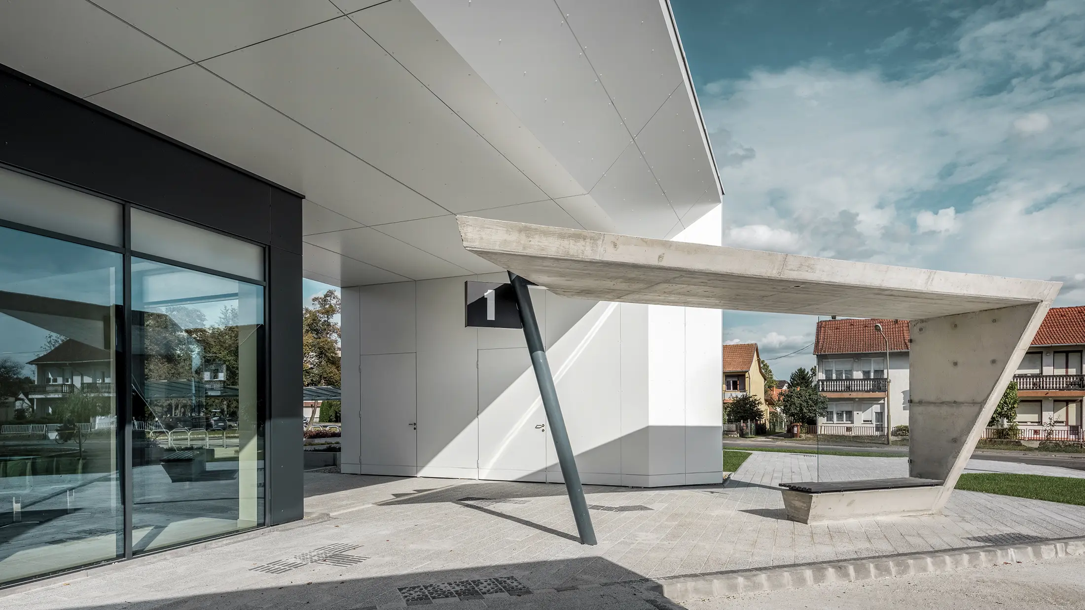 Indgangspartiet til busstationen i Lenti; undersiden af overdækningen er beklædt med PREFABOND aluminiumskompositplade fra PREFA i ren hvid, mens facadeelementerne ved indgangsdørene og udstillingsvinduerne er beklædt med P.10 antracit.