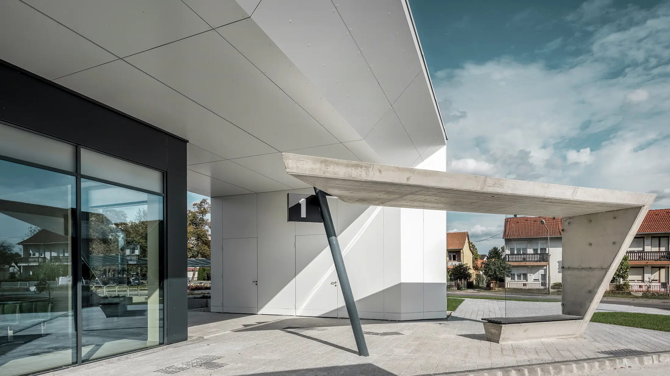 Indgangspartiet til busstationen i Lenti; undersiden af overdækningen er beklædt med PREFABOND aluminiumskompositplade fra PREFA i ren hvid, mens facadeelementerne ved indgangsdørene og udstillingsvinduerne er beklædt med P.10 antracit.