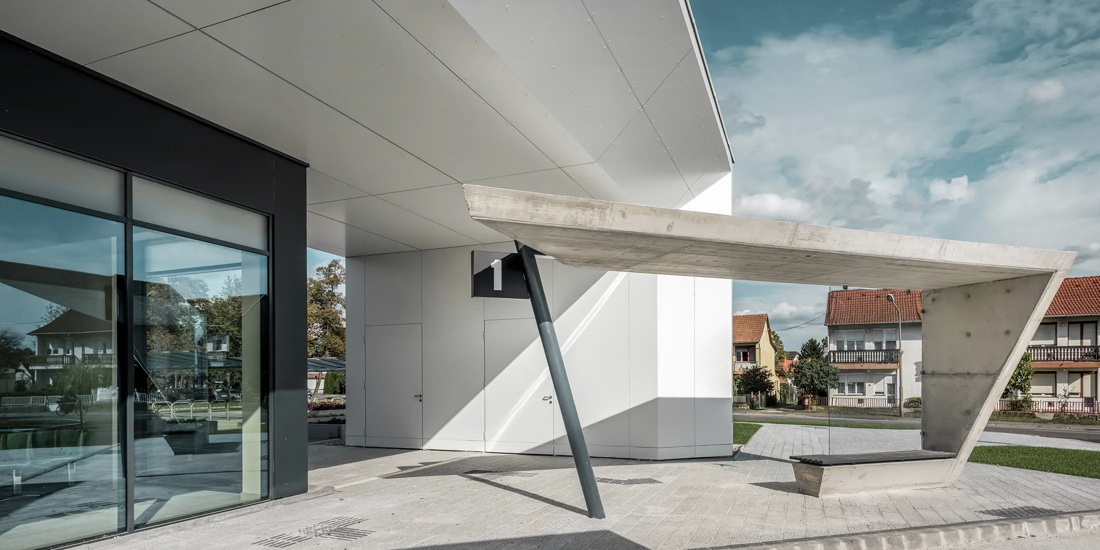 Indgangspartiet til busstationen i Lenti; undersiden af overdækningen er beklædt med PREFABOND aluminiumskompositplade fra PREFA i ren hvid, mens facadeelementerne ved indgangsdørene og udstillingsvinduerne er beklædt med P.10 antracit.