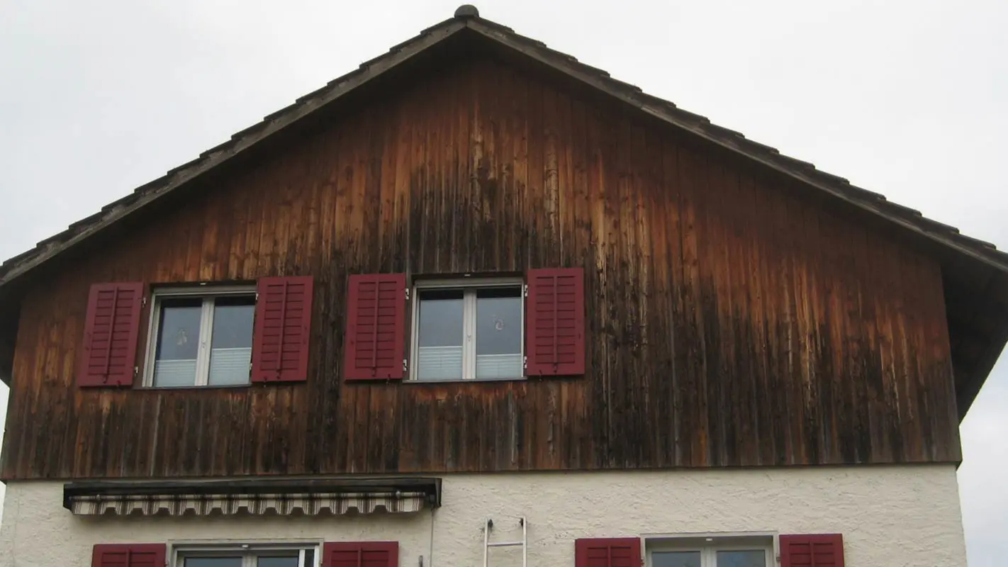 Husfacade med forvitret træ, før renovering med PREFA sidings