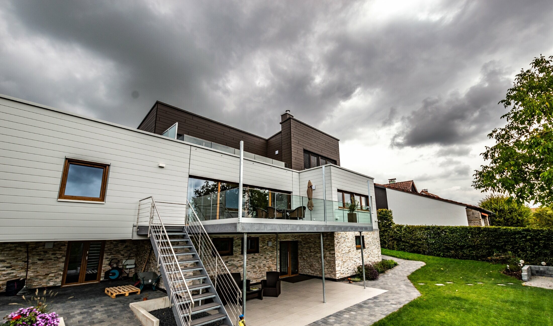Beboelseshus med fladt tag og hvid og brun facade med PREFA Siding monteret vandret.