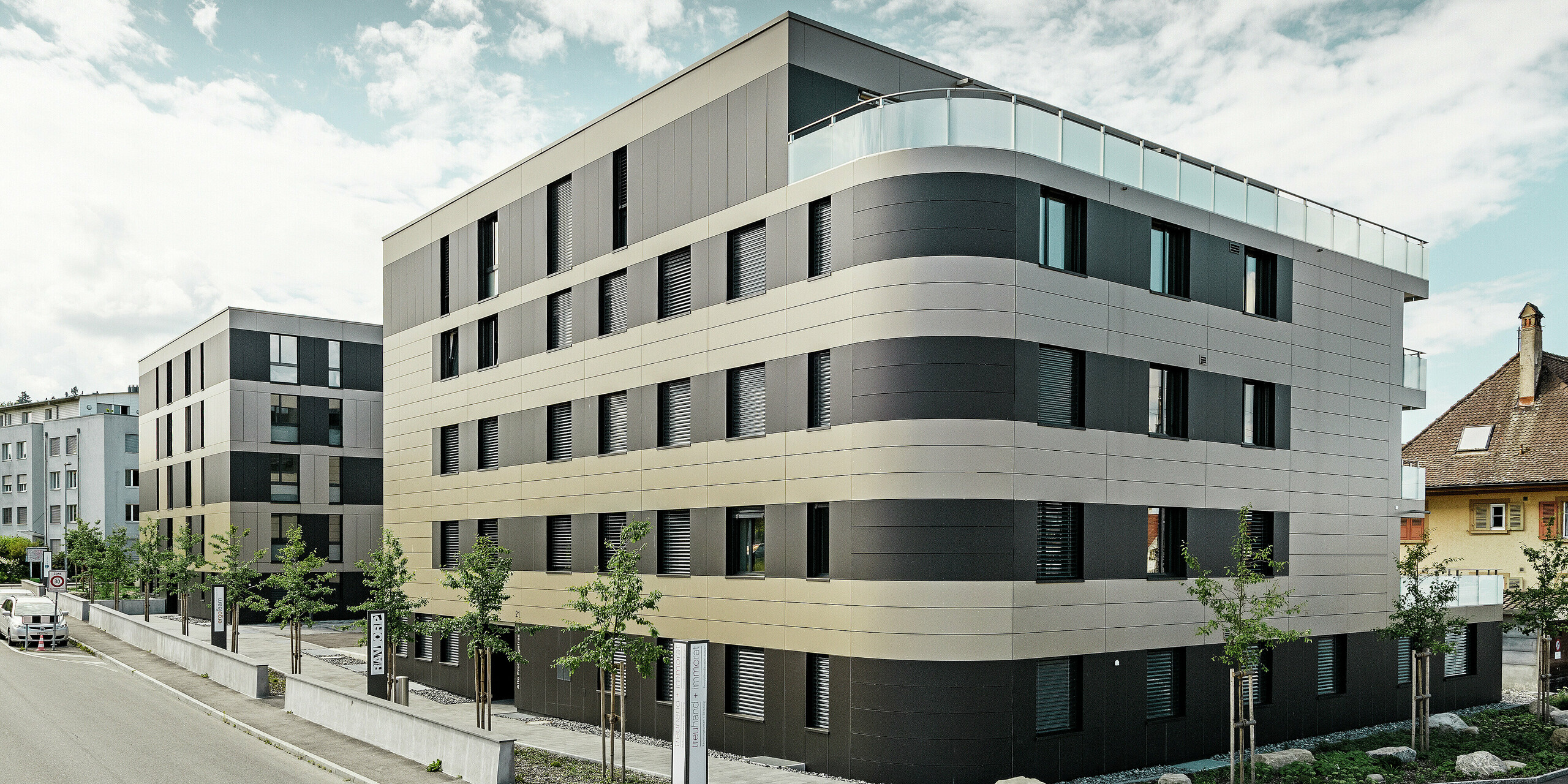 Terningformet boliganlæg med en aluminiumfacade i bronze med sortgrå elementer