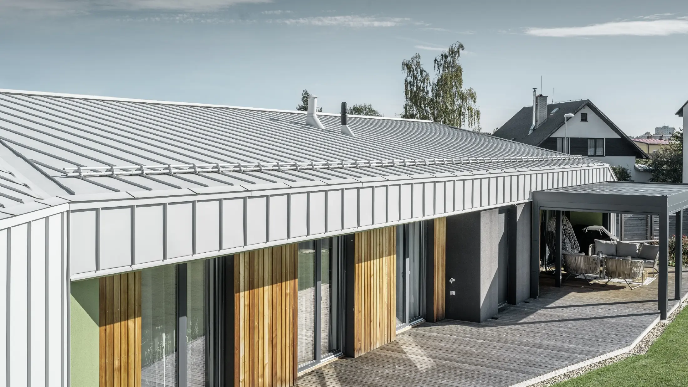 Bungalow med PREFALZ-tag og -facade i Prefa-hvid og træterrasse