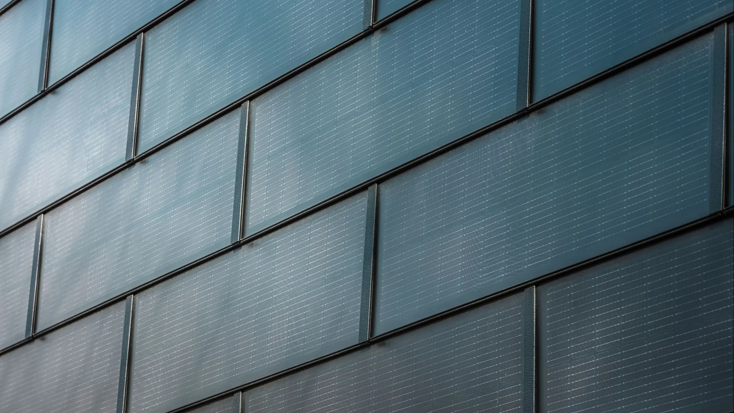 Nærbillede af PREFA-solcelletagplade, der er monteret på en facade.