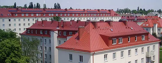 Billede af boligbyggeriet Hugo Breitner Hof i Wien. Tagene er beklædt med PREFA tagspån i teglstensrød.