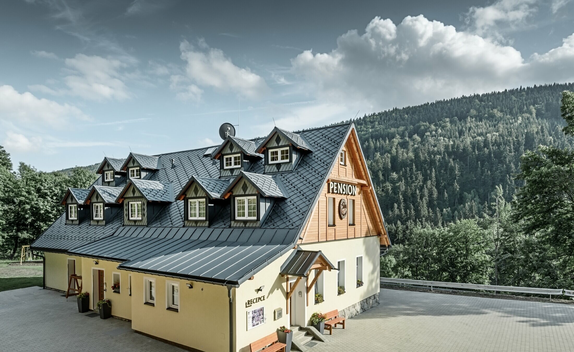 Pension in Tschechien mit Steildach und vielen Gauben eingedeckt mit Aluminiumdach von PREFA, schuppiges Rautendach mit Schneeschutz